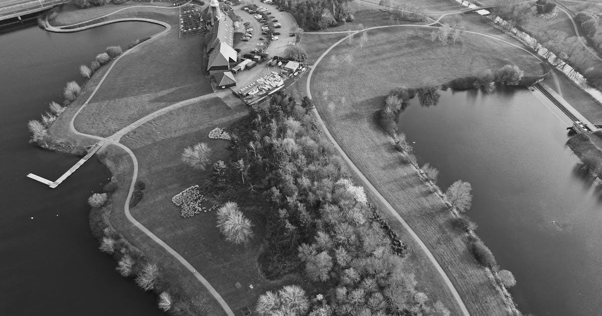 Aerial view of a golf course with clubhouse surrounded by lush English countryside
